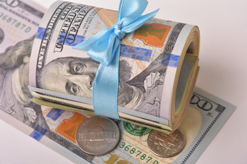 Dollar banknotes, coins and blue bow