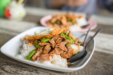 Rice topped with Meat with String Beans and fried egg served