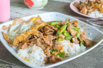 Rice topped with Meat with String Beans and fried egg served