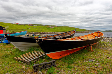 Obraz premium Old wooden boats stored on shore at Sandwick on the Main Shetland Isle, which is located northeast of the Scottish mainland