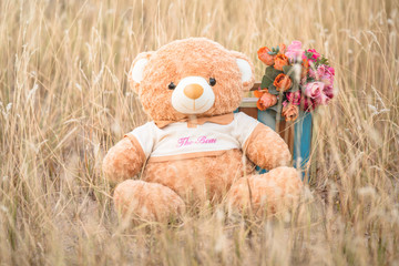 Teddy bear is on a beautiful flowers