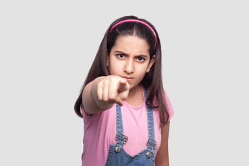 Hey you! Portrait of serious brunette young girl in casual style, pink t-shirt and blue denim...