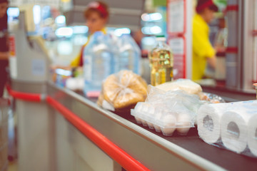 supermarket cashier with food on the conveyor to purchase on the weekend