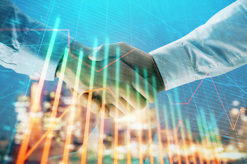 Double exposure of financial chart on cityscape background with two businessmen handshake. Concept of financial analysis and investment opportunities