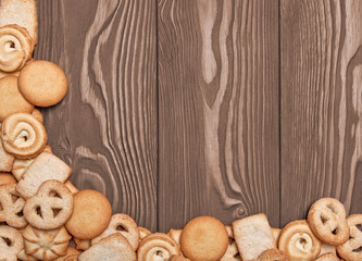 Cookies of different shapes on a wooden background with a corner design