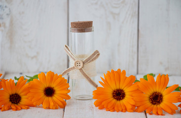 Bottle of calendula tincture, with fresh calendula flowers