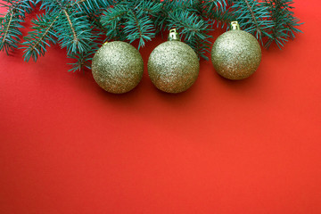 Fototapeta na wymiar Christmas background. Golden balls and fir branches on a red background. Place for text.