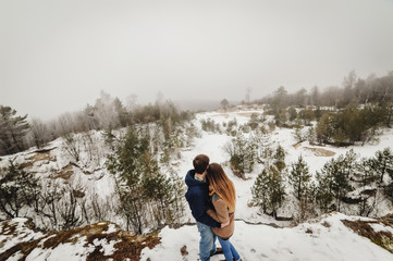 Happy couple walking on the snowy winter nature. Happy boy and girl. Happy holidays. Merry christmas and happy new year concept.