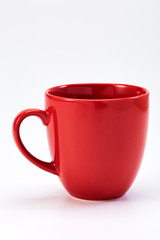 red ceramic mug on white background