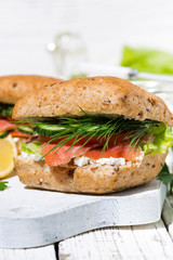 sandwich with salted fish and cream cheese on white wooden board, vertical closeup