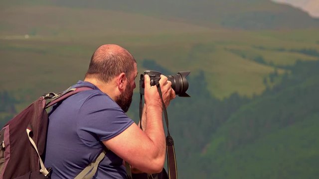 Photographer traveler taking pictures of landscape in the mountains