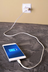 Mobile smart phones,phone charging on rock desk