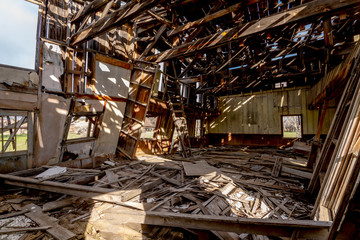 The interior of an old wood framed building slowly falling down