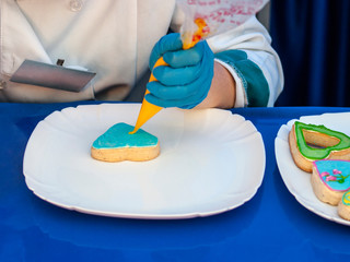 The confectioner is drawing a drawing on pastries