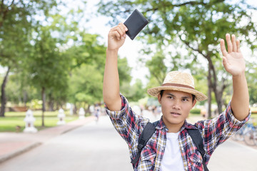 Asian tourist looking and finding the owner of black wallet that he found in tourist attraction