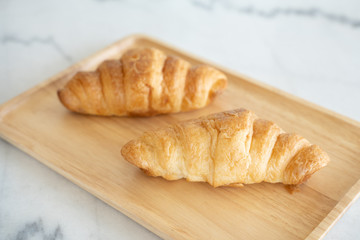 A Couple of Croissants on the wooden plate.