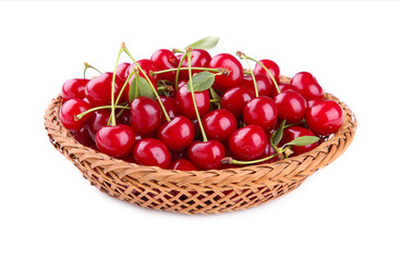 Cherry in wooden basket with leaves isolated on white background