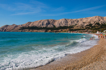  people resting on the beach on the famous beach in Baska