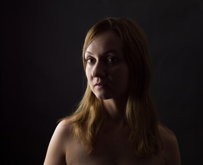 Fototapeta premium portrait of young woman, no make up, low key, brown dark hair, natural looking making expressions 