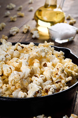  Prepared popcorn in frying pan, corn seeds in bowl and corncobs on kitchen table.Air salty popcorn. Salt popcorn on the wooden background . Chees .Popcorn texture
