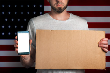 Concept of freedoms and human rights. A man with a cardboard and a phone in his hand. The Flag of...