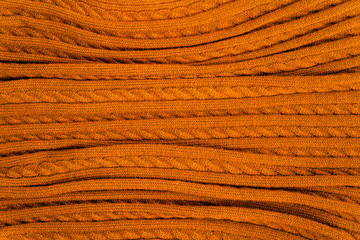 Knitted blanket in autumn colors. Soft and warm fabric. Texture for background or illustrations.