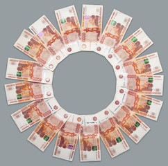 Russian paper banknotes in denominations of five thousand rubles lying around on the grey background