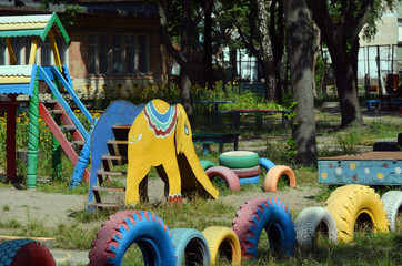 Painted car tires for kindergarten playground equipment.Modern ghetto. Bad district. Residential...