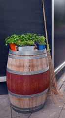 barrel with herbs on top with a broom