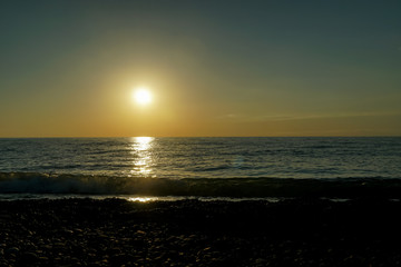 Fototapeta premium Beautiful sunset on the Black Sea in Batumi, Georgia. Dazzling orange sunset on the black sea, the sun goes over the sea
