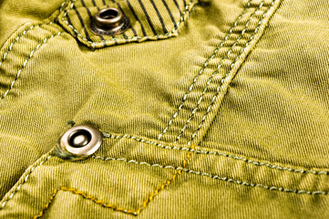 clothing items stonewashed cotton fabric texture with seams, clasps, buttons and rivets, macro