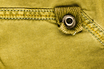 clothing items stonewashed cotton fabric texture with seams, clasps, buttons and rivets, macro