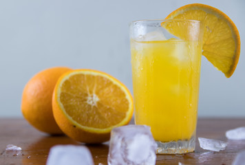 Naklejka na ściany i meble Orange juice with ice on a wooden table