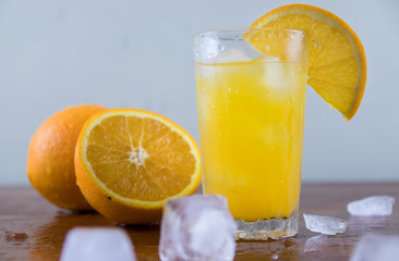 Orange juice with ice on a wooden table
