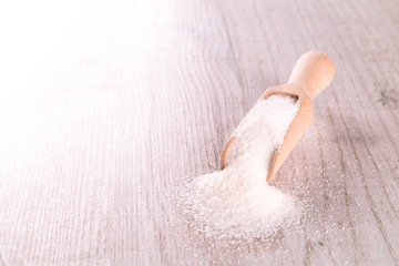 White cane sugar on a light wooden background