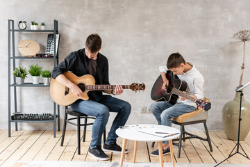 Young boy and his father learn to play guitar. Musical education. Education with family