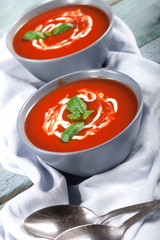 Traditional spanish cold tomato soup gazpacho in a bowl over blue wooden background.
