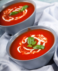 Traditional spanish cold tomato soup gazpacho in a bowl over blue wooden background.