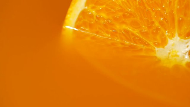 Texture of a cut mandarin orange in orange juice close-up, Rotation of orange slice and orange juice