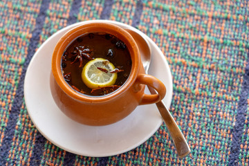 Cinnamon toddy consisting of cinnamon, black pepper, cardamom, star anise, lemon, cloves and hot apple juice in the street cafe of Rishikesh, india. Close up . Cinnamon tea. Tea drink
