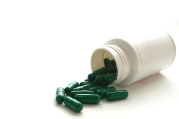 Medicine green  pills or capsules and aluminum foil blister on  white background with copy space.  treatment medication