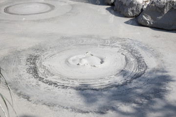 Fototapeta na wymiar closeup of gray mud boiling bubble hell hot springs at Japan.
