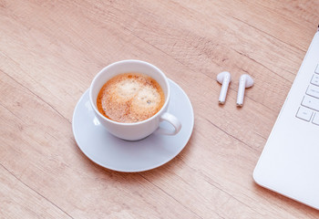 Coffee, laptop and headphones on wooden table. Relax concept