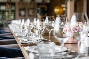 Wine glasses in the foreground. Wedding Banquet or gala dinner. The chairs and table for guests, served with cutlery and crockery.