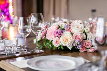 Wine glasses in the foreground. Wedding Banquet or gala dinner. The chairs and table for guests, served with cutlery and crockery.