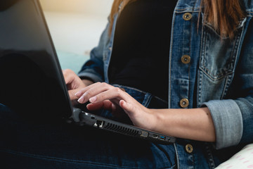 Cropped hand of woman using laptop in home, copy space, technolgoy communication