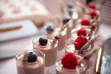 Hochzeitstorte mit Blumen und Beeren und weißem Zuckerguss.