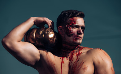 Big zombie man halloween vampire or bloody war soldier with wounds and red blood with pumpkin....