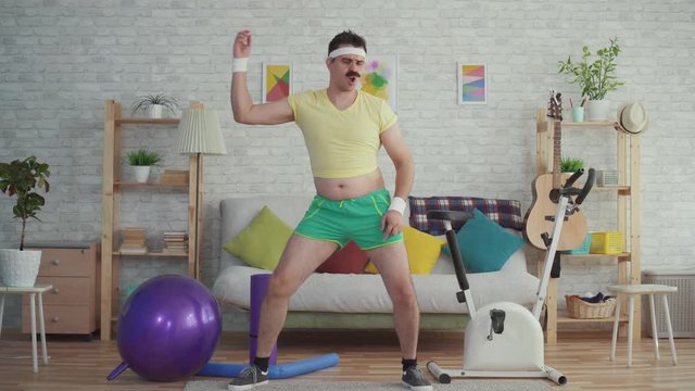 Expressive overweight man with a mustache and glasses funny dancing