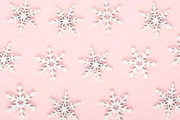 Christmas background. White snow decorations on a pink background.